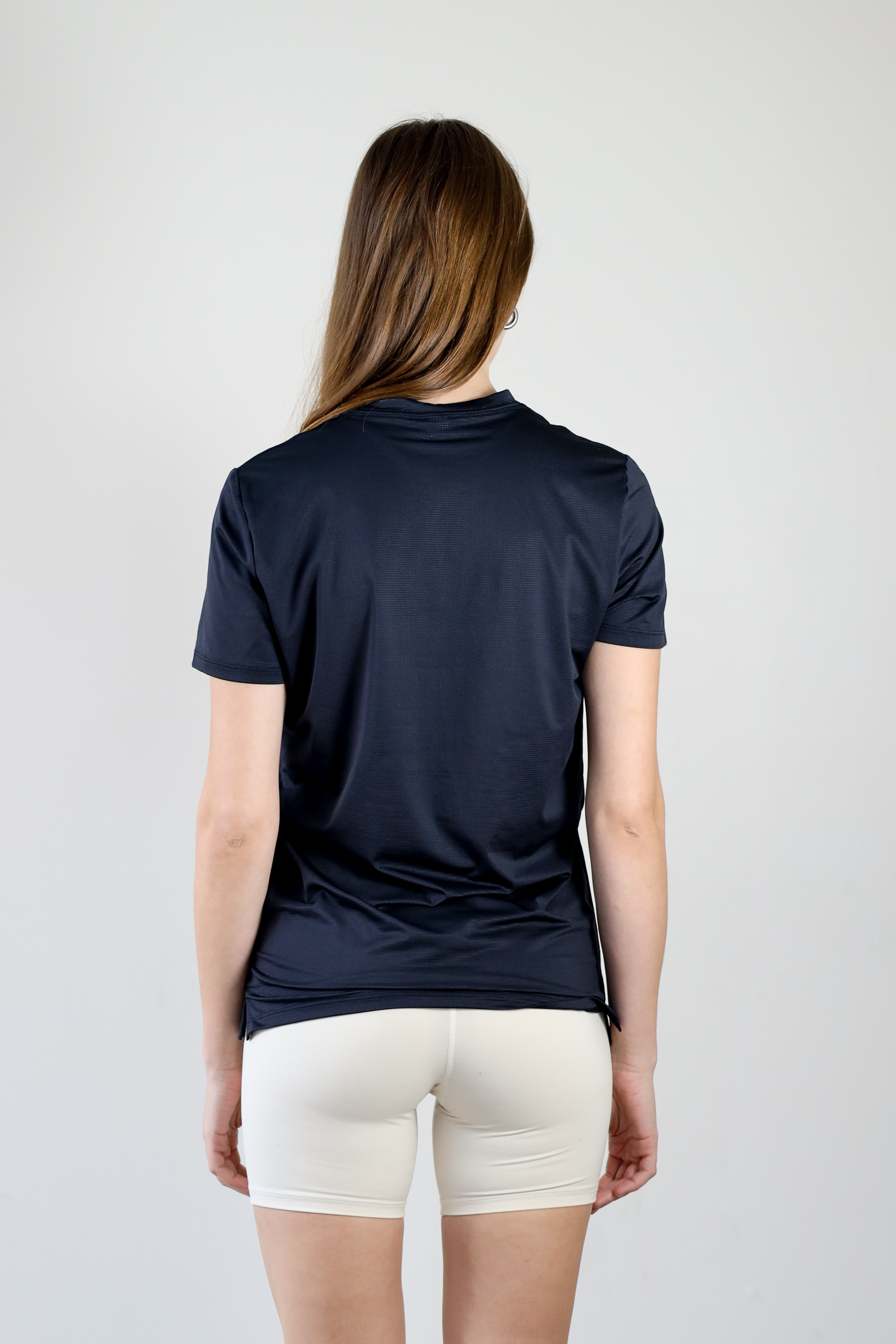  rear view of a model in the black Unisex Short Sleeve Runners Tee, showcasing the minimalist back design, high-performance mesh material, and comfortable, streamlined cut.