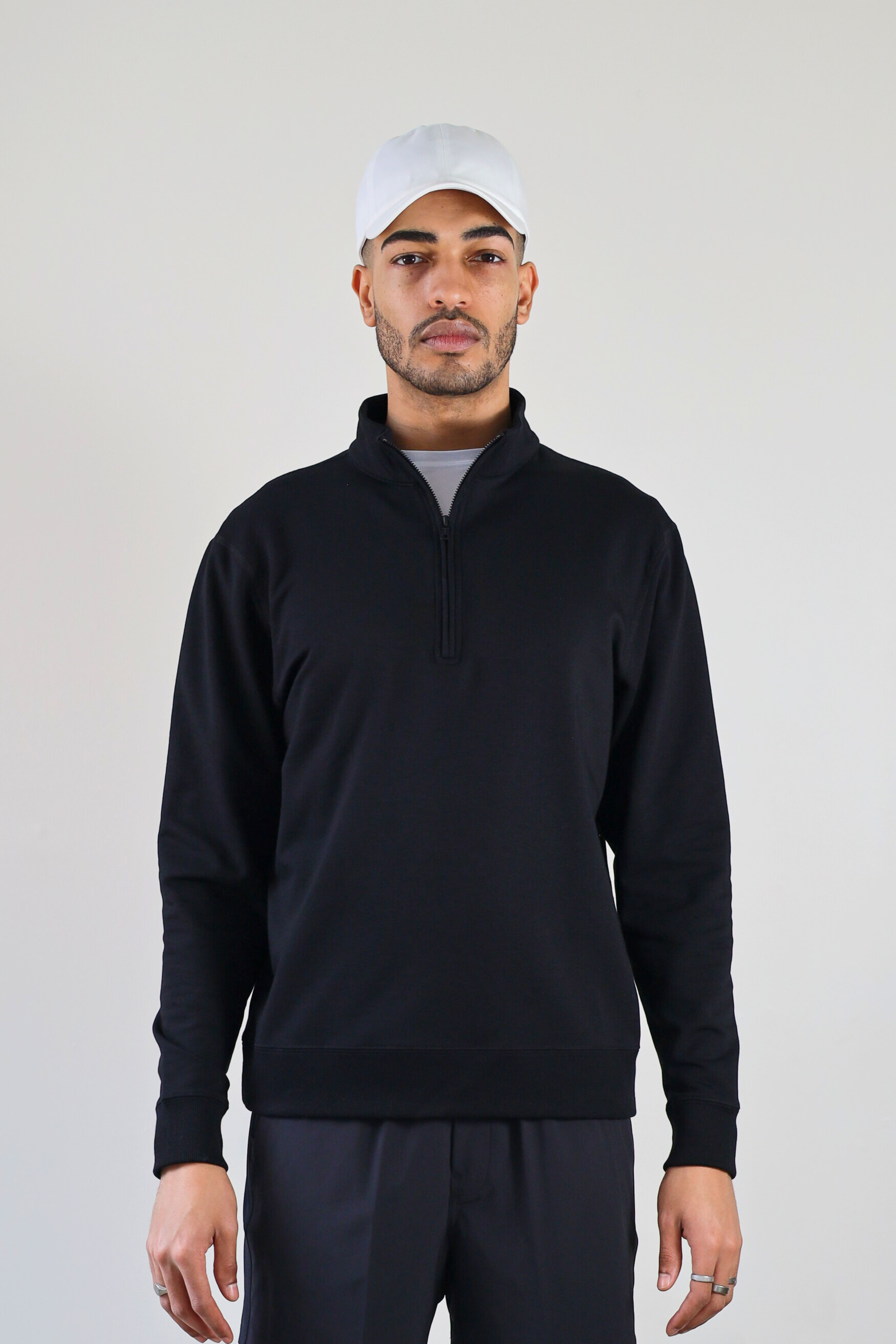 Men’s 1/4 Zip Crewneck in Black – front view on model featuring structured fit, minimal branding zone, and ribbed hem